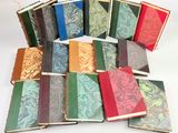 many different colored books lined up on a white surface