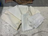un tas de tissu blanc posé par terre à côté d'un tapis