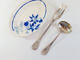 two spoons and a plate with blue flowers on it