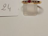 a close up of a gold ring with a red stone on it
