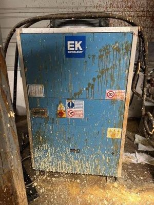 a blue refrigerator in a dirty room with a lot of dirt on the floor
