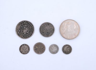 an assortment of coins and a coin on a white surface