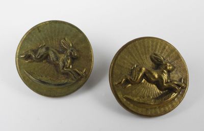 a pair of brass buttons with a horse and rider on them