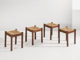 un ensemble de quatre tabourets en bois avec des assises en rotin dans une pièce blanche