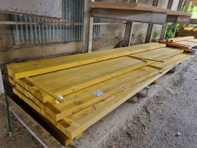 Dans un bâtiment, plusieurs morceaux de bois sont empilés les uns sur les autres.