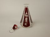 a small glass bottle with a red and white design on it