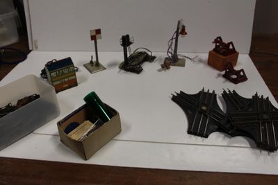 une table sur laquelle se trouvent plusieurs circuits de train miniature et une boîte sur laquelle est représentée une chauve-souris