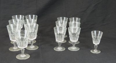 six verres à vin transparents sont alignés sur un fond noir