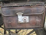 a brown suitcase sitting on top of a bike