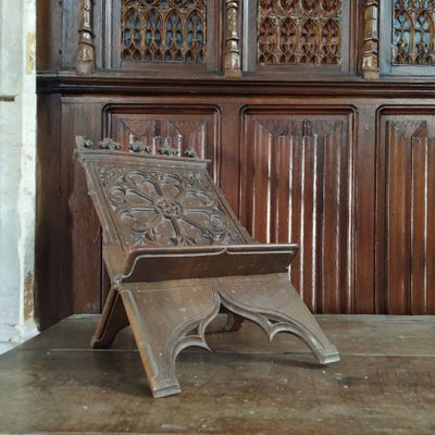 un banc en bois posé devant un mur lambrissé