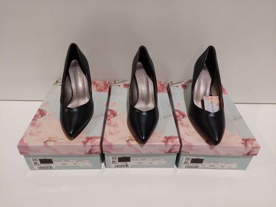 trois paires de chaussures à talons hauts noires posées sur une boîte
