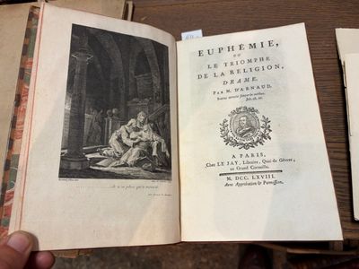 une personne tenant un livre ouvert sur une table
