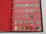 a red book with a bunch of coins inside of it
