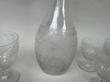 bottles and glasses are lined up on a table with a white background