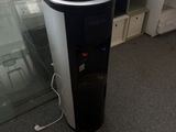 un distributeur d'eau noir et blanc à côté d'une porte vitrée
