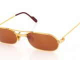 lunettes de soleil dorées aux verres marron sur fond blanc