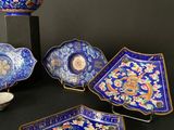 several pieces of blue and gold decorated plates and bowls on a table
