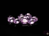 some very pretty purple gems on a black surface