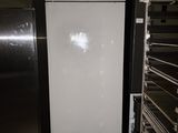 a white refrigerator in the middle of a room next to shelves