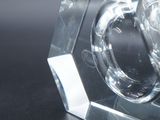 a crystal object on a black table with a black background