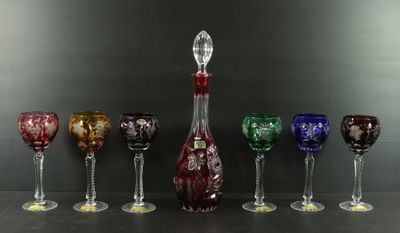 Plusieurs verres à vin et une carafe sont alignés sur une table