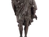statue en bronze représentant un homme coiffé d'un chapeau et vêtu d'une cape, tenant une canne