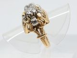 a close up of a gold and diamond ring on a clear surface