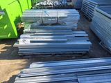 a pile of metal sheets sitting on top of a pile of dirt