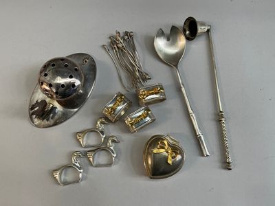 de nombreuses cuillères en argent et d'autres objets sur la table