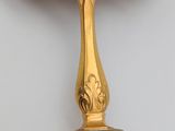 an image of a spoon with a gold handle on a wall