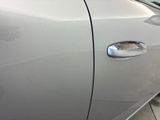the door handle of a silver car is shown with the door handle open