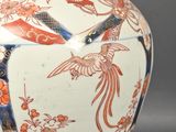 a vase that has a bird on it and a bird on it
