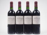 three bottles of red wine are lined up on a white surface