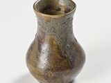 a small vase that is sitting on a white surface