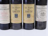 four bottles of wine are lined up in a row on a white surface