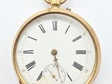 a gold pocket watch with roman numerals on the face