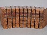 six vieux livres sont empilés sur une table