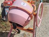 a pink cement mixer sitting in front of a building