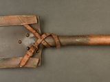 an old wooden spatula with a leather handle on a gray surface