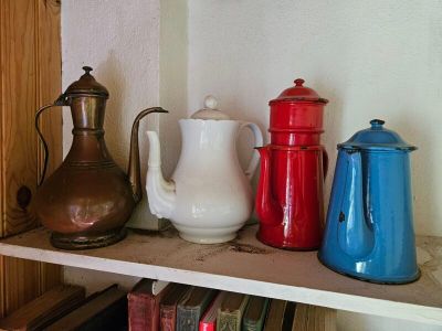 une étagère sur laquelle sont disposées diverses cafetières et théières