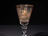 a close up of a wine glass on a table with a black background