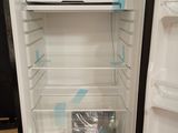 a refrigerator with its door open on a wooden floor