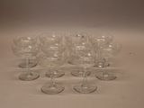 several empty wine glasses are lined up on a white surface