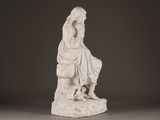 statue of a woman sitting on a rock with her hands on her knees