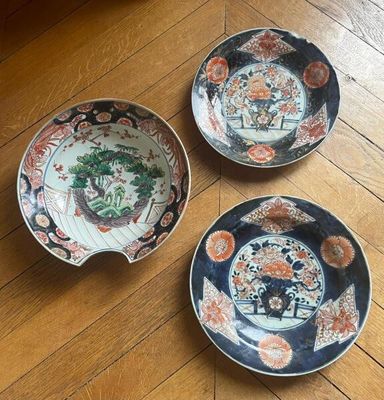 three plates that are sitting on a wooden floor