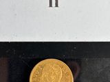 an image of a gold coin sitting on top of a black surface