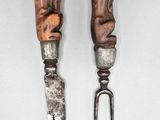 two forks with carvings on them sitting next to each other