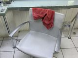 a white chair with a red towel on it in front of a mirror