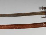une paire de sabres japonais anciens exposés sur un support blanc