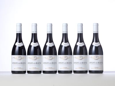 six bottles of red wine lined up in a row on a table